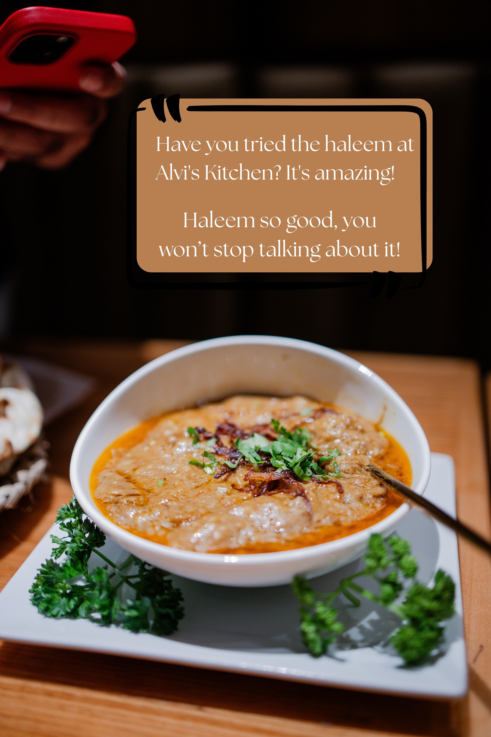 A bowl of haleem being photographed at the table